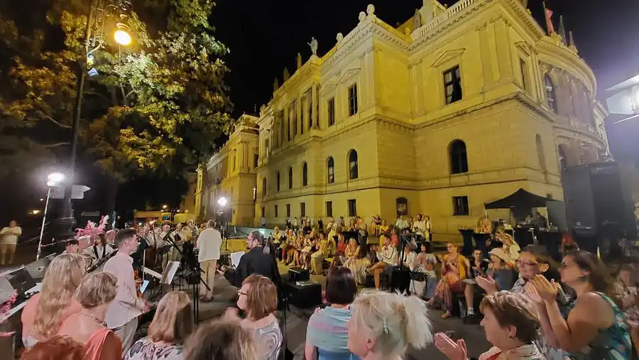 Večerní publikum před historickou budovou